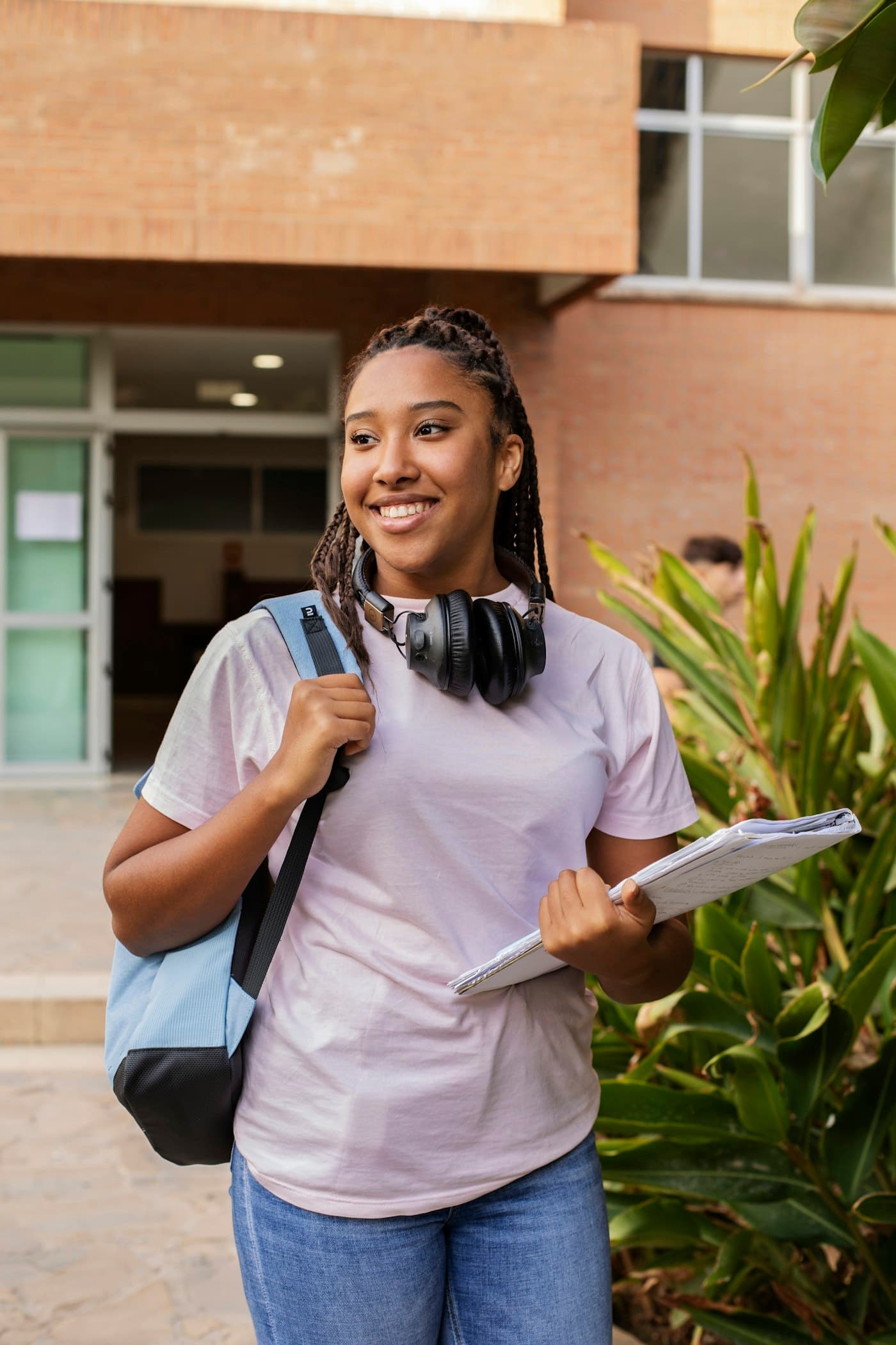 Estudante universitária sorridente com mochila num campus